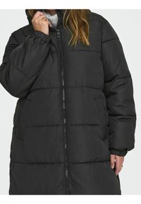 Zwarte pufferjas met een capuchon, uitgerust met een ritssluiting en elastische manchetten. Gemaakt van een zachte, doorgestikte stof met zijzakken.