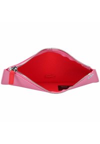Pochette zippée rose avec un extérieur lisse, contenant un intérieur rouge texturé. Fermeture éclair argentée et petit détail d'accent rouge.