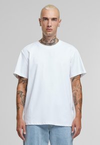 Witte katoenen t-shirt met een ronde hals, korte mouwen en een ontspannen pasvorm. Opvallend door de zachte textuur en het eenvoudige ontwerp.