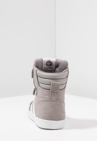 Szare zamszowe sneakersy typu high-top z białą podeszwą, z wyściełanym kołnierzem, rzepami oraz subtelnymi szarymi akcentami na pięcie i bokach.