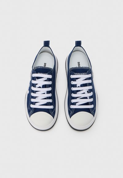 Ναυτικά πάνινα παπούτσια με λευκά κορδόνια, λευκή λαστιχένια προστατευτική μύτη και αντίθετη σόλα. Διαθέτουν λογότυπο στην πλευρά και θηλιά στο πίσω μέρος.