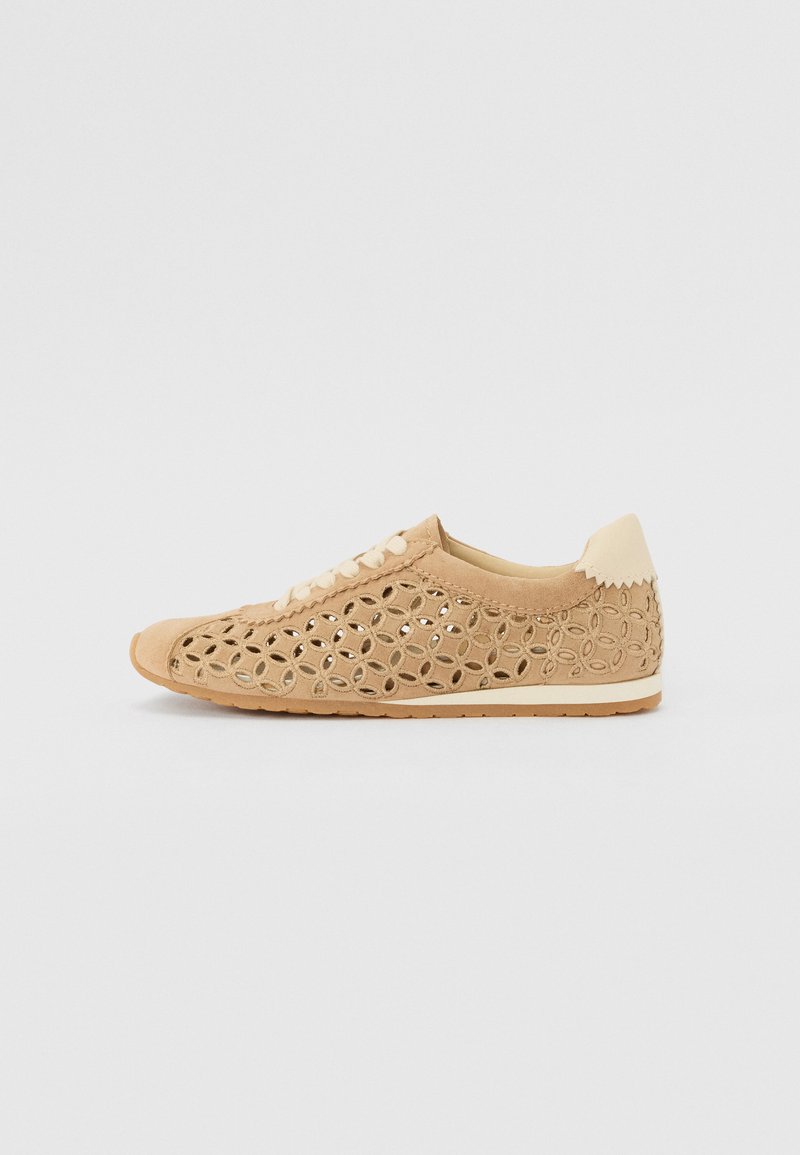 Beige perforerede sneakers med en blød suede-overdel, rund tå, snørebånd foran og struktureret tan gummisål. Pyntet med blomsterudskæringer.