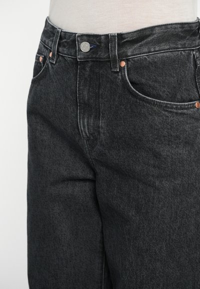 Zwarte denimspijkerbroek met een hoge taille, voorzien van hardware in kopertoon en klassieke zakken. De stof heeft een zachte, licht vervaagde textuur.