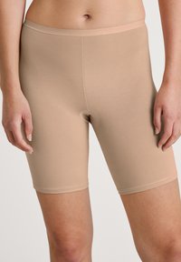 Nude seamless stretch bike shorts with a minimalist design, featuring an elastic waistband and smooth texture, suitable for layering.