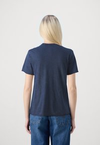 Camiseta de manga corta azul marino con cuello redondo y un corte estándar, elaborada en suave material de algodón. Sin patrones o acentos notables.