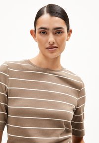 Bruine gestreepte t-shirt met korte mouwen. Zacht katoenen materiaal met witte horizontale strepen en een ronde halslijn. Glad textuur.