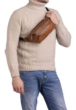 Marsupio in pelle marrone con cerniere, tracolla regolabile e design elegante, indossato a tracolla sopra un maglione beige a maglia cable-knit.