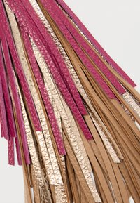 Lagdelte lærfringe-striper i rosa, gullmetallisk og tanfarger som overlapper hverandre på en hvit bakgrunn.