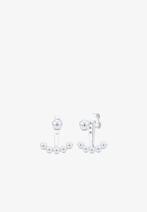 Srebrne kolczyki o minimalistycznym designie, z trzema małymi kulkami na zakrzywionym pręcie, uzupełnione większą kulką na górze.