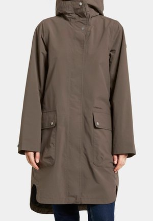 Brauner knielanger wasserdichter Mantel mit Kapuze, vorderen Druckknopftaschen und langen Ärmeln, getragen über blauen Jeans.