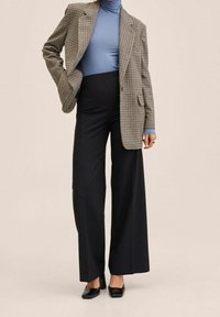 Houndstooth blazer, light blue turtleneck, wide black trousers, and black heels; structured design with contrasting textures and patterns.