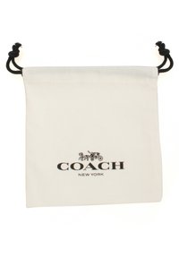 Hvid stofopbevaringspose med snorelukning, der har et sort "COACH NEW YORK" logo og grafisk silhuetdesign øverst.