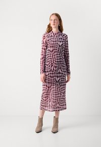 Lang, getailleerde jurk met een roze en zwarte geruite print, gemaakt van doorschijnend materiaal met een hoge halslijn en lange mouwen.