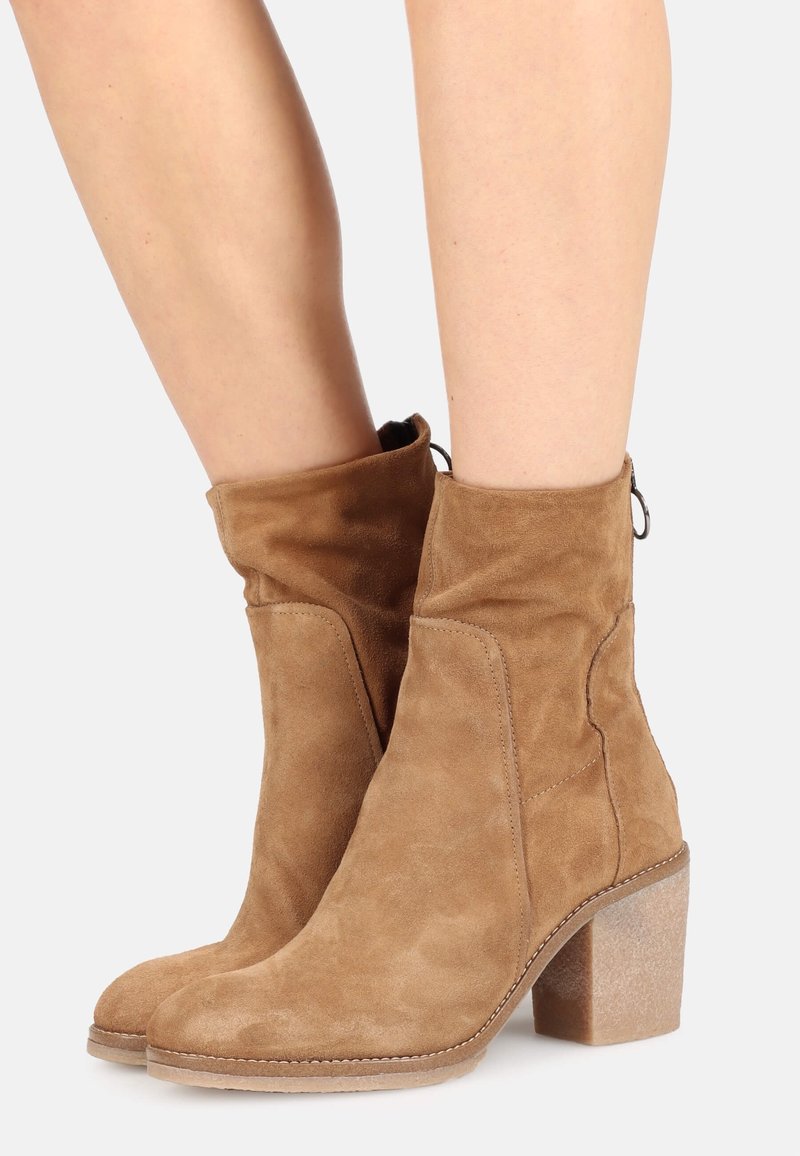 Bottines en daim marron avec un embout arrondi, une tige décontractée et un talon carré texturé. Dotées de détails de couture et d'une languette à l'arrière.