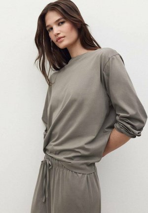 Top de corte holgado, de manga larga y cuello redondo, en suave tela gris apagado, con mangas con puños y una cintura ligeramente fruncida.