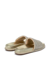 Sandalias deslizantes doradas con un empeine adornado con brillantes de strass, plantilla metálica suave y perfil plano sin talón.