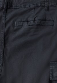 Pantalones oscuros de navy fabricados con tela suave, que cuentan con un bolsillo trasero con una solapa rectangular y detalles de costura sutiles.