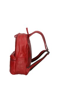 Sac à dos en cuir rouge avec une texture lisse, poche zippée et bretelles réglables brunes. Possède une forme arrondie et un design minimaliste.