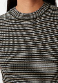 Czarna i biała bluzka w paski z wysokim kołnierzem, teksturowanym dzianinowym wzorem oraz odblaskowymi akcentami w srebrnych i złotych odcieniach.