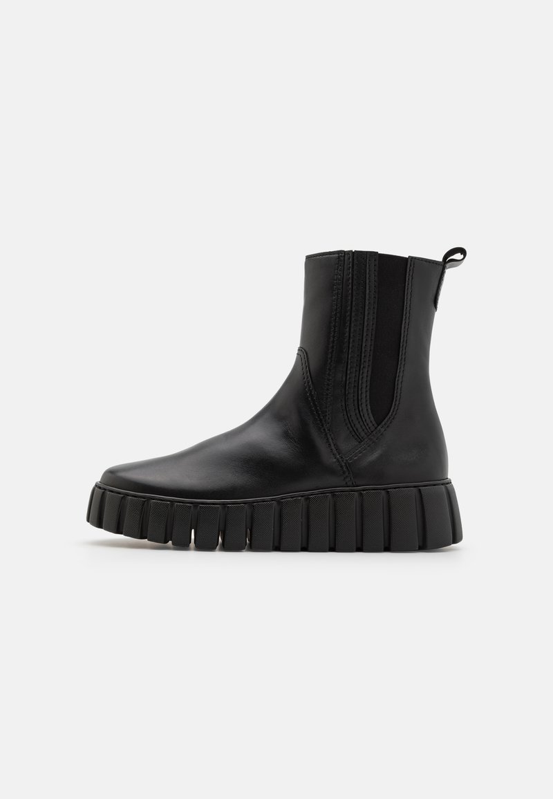 Schwarze Leder Stiefelette mit elastischen Seiteneinsätzen, dickem geripptem Sohle und Zuglasche an der Ferse. Glatte Textur und schlankes Design.
