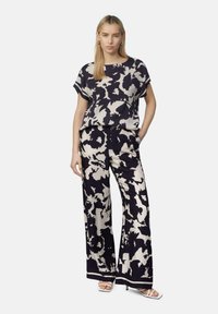 Bluse mit floralem Muster und weit geschnittenen Hosen in Marineblau und Creme. Hergestellt aus leichtem Stoff mit glatter Textur und lockerer Passform.