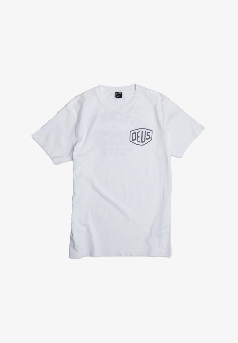Camiseta blanca de algodón con un logo negro "DEUS" en el lado izquierdo del pecho, mangas cortas y un diseño clásico de cuello redondo.