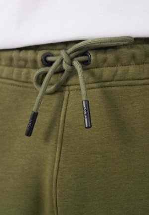 Olijfgroene joggers met een gevlochten trekkoord, voorzien van zwarte kunststof aglets en een gestructureerde stofafwerking.