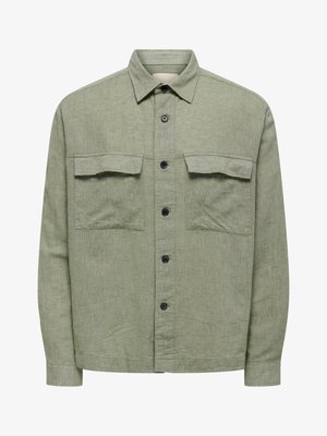 Camisa verde claro de manga larga con botones, dos bolsillos de solapa en el pecho y cuello clásico, hecha de tela texturizada.