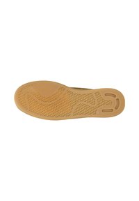 Zool van een bruine rubberen schoen met een gestructureerd grip-patroon en drie ovale uitsparingen nabij de hiel op een witte achtergrond.