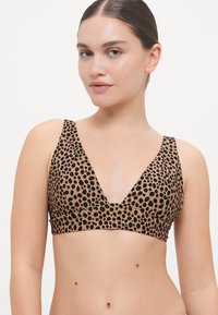 Bralette en imprimé léopard marron avec un décolleté en V profond, des bretelles larges et une texture de tissu lisse. Convient pour le port décontracté ou pour se détendre.