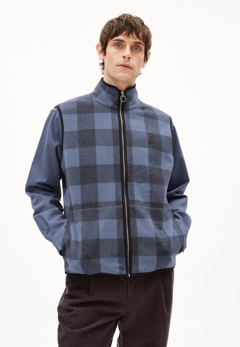 Männer Steppweste in Blau mit Karomuster, ausgestattet mit hohem Kragen, Seitentaschen und einem Logo auf der Brust. Hergestellt aus weichem Stoff.