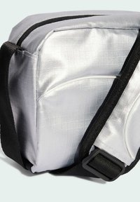 Silberne Umhängetasche mit strukturiertem Finish, schwarzem Riemen und weißen Akzenten. Verfügt über einen Reißverschluss und eine rechteckige Form.