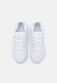 Une paire de baskets blanches de sport avec une tige en maille, un col rembourré et un design à lacets, vue d'en haut sur un fond clair.