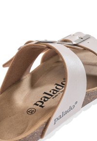 Sandal in pelle bianca con fasce incrociate, una soletta in sughero e dettagli in metallo argentato. Soletta stampata con "palado" e misura 37.