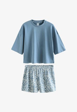 Top albastru cu mâneci scurte, croială lejeră, asortat cu pantaloni scurți cu talie elastică, imprimeu floral în albastru deschis și alb.