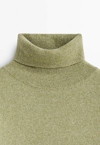 Hellgrüner Rollkragenpullover mit einer gerippten Textur, der einen hohen Kragen und ein eng anliegendes Design aufweist. Weicher Stoff mit leichtem Stretch.