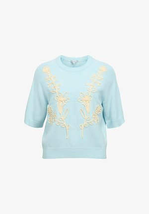 Lyseblå kortermet strikkegenser med kremfarget blomsterbroderi på forsiden og ribbestrikkede mansjetter og kant.