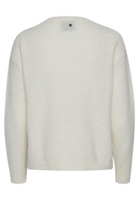 Pull de couleur crème au fit décontracté, manches longues, ourlet côtelé et col rond. Tissu en tricot doux et texturé avec un minimum de détails.