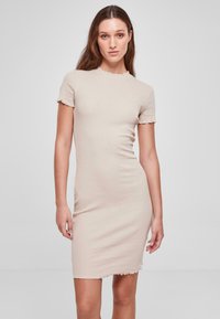 Robe beige à rayures de longueur genou, avec des manches courtes et un col et un ourlet festonnés. Fabriquée dans un matériau ajusté et extensible.