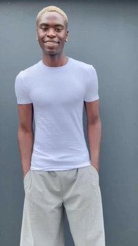 Világos szürke, rövid ujjú, testhezálló póló, laza, világos bézs nadrággal párosítva. Sima textúra, minimalista dizájn.