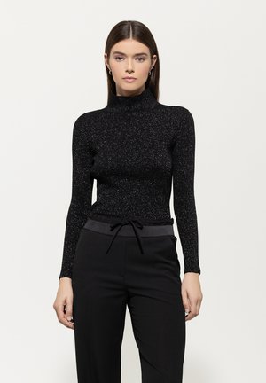Black long-sleeve top with a high neck, made of textured, sparkly material. Paired with black pants featuring a drawstring waist.