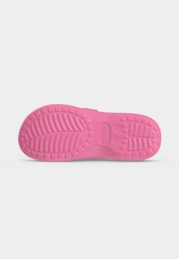 Σόλα ροζ παπουτσιού Crocs προς τα πάνω, που δείχνει το σχέδιο πέλματος και τις ενδείξεις μεγέθους σε λευκό ομαλό φόντο.