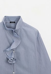 Blouse à fines rayures bleues et blanches avec un détail froncé sur le devant et des boutons blancs, présentée sur fond blanc.