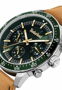 Žalias ir auksinis Timberland laikrodis su nerūdijančio plieno korpusu, odiniu dirželiu, kronografų ciferblatais ir švytinčiomis valandų žymėmis.