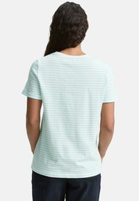 T-shirt à manches courtes rayé bleu clair en tissu doux, avec un col rond et une coupe décontractée, ornée de rayures horizontales discrètes.