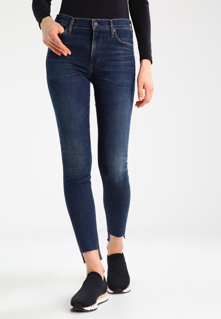 Smala jeans i mörkblå denim med hög midja, subtila blekningar och rå kant. Tillsammans med svarta slip-on skor.