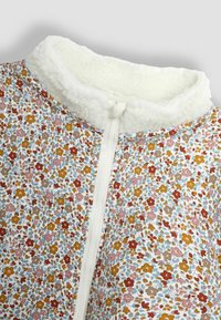 Giacca a fantasia floreale con colletto in morbido fleece bianco, zip frontale e colori vivaci tra cui accenti di rosso, giallo e blu.