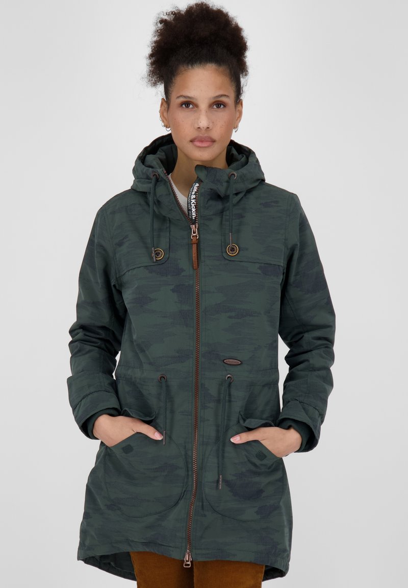 Parka verde mimetica con chiusura a zip, cappuccio con cordino, due tasche frontali e dettagli marroni. Realizzata in un materiale testurizzato e resistente.