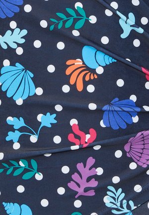 Navy fabric with white polka dots features colorful sea-themed patterns, including shells and coral in shades of blue, green, orange, and purple.