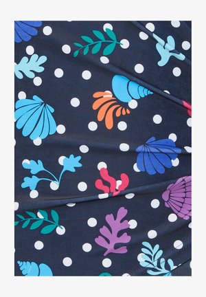 Navy fabric with white polka dots features colorful sea-themed patterns, including shells and coral in shades of blue, green, orange, and purple.